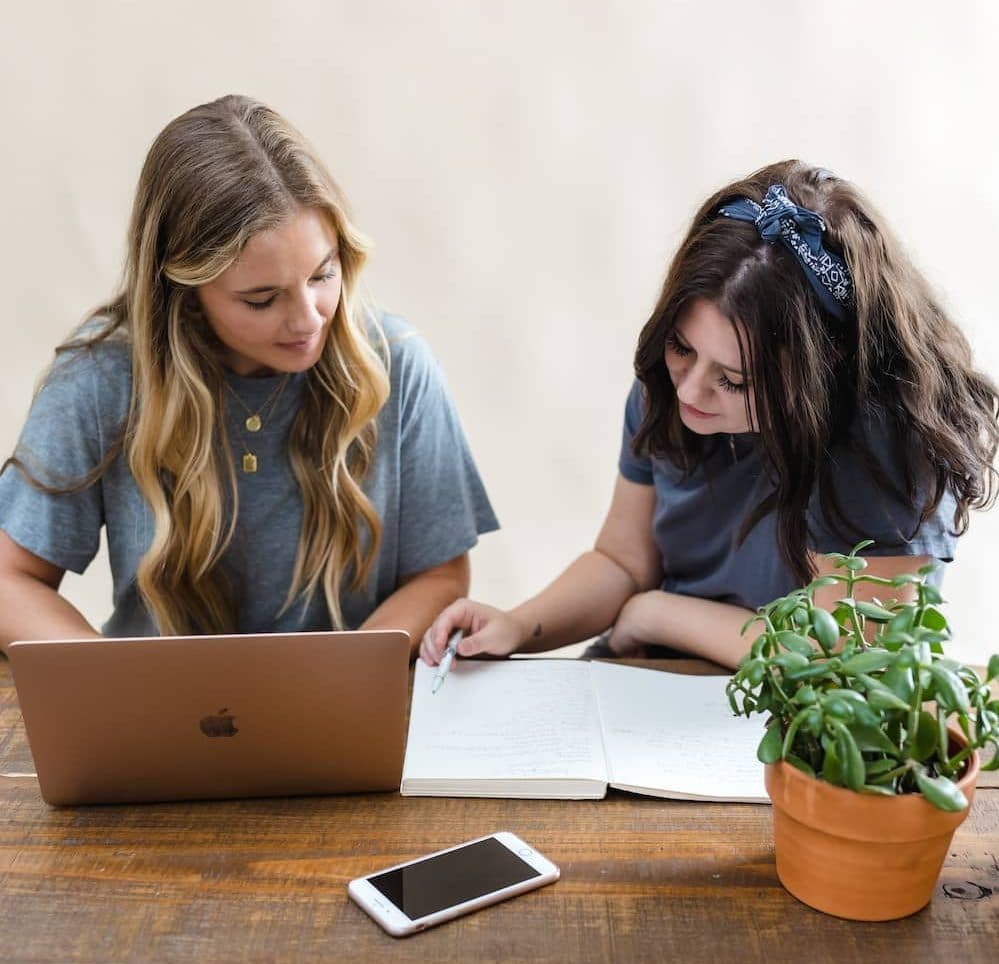 Dos chicas con ordenador estudian formación de inglés para empresas